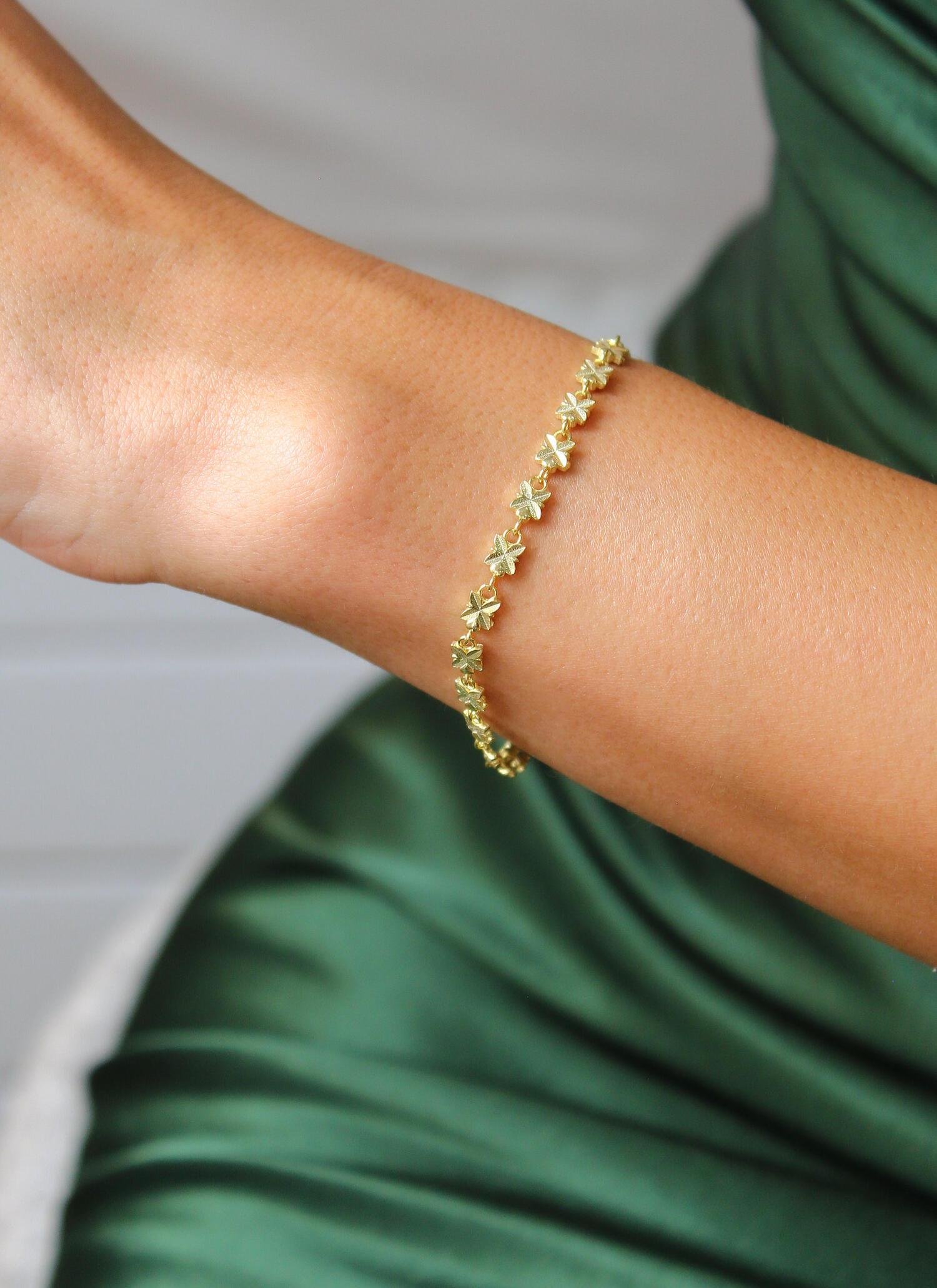 Female shape in green silk dress and gold bracelet, from Saudi Arabia Luxury Marketing and Media Agency